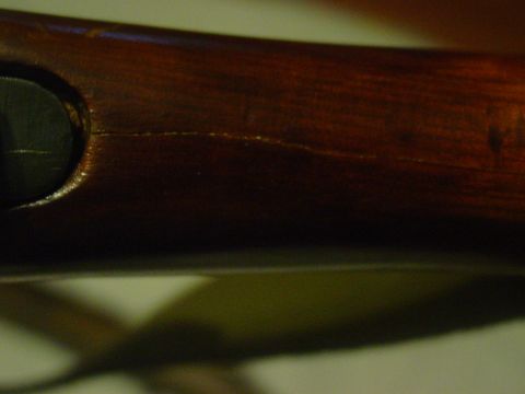 1979 Ford Bronco - Wooden rifle stock shows a crack and a dark circular insert, with Supermotors.net logo in the corner.