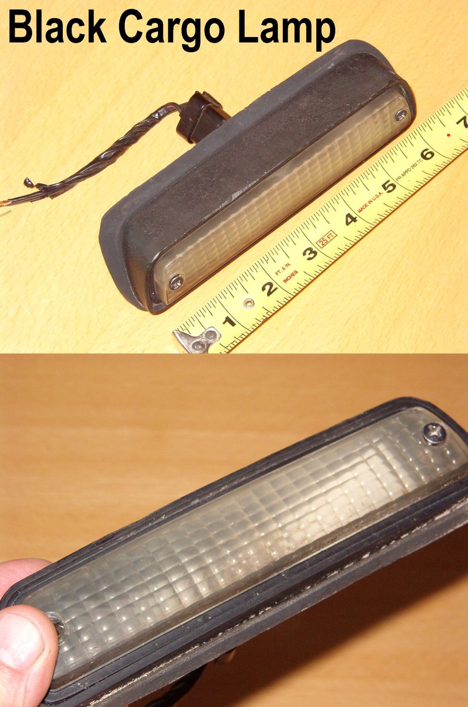 Black cargo lamp measured against a ruler, around 6 inches long