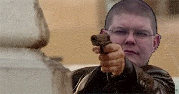 2000 Mercury Grand Marquis - A man points a handgun forward, seemingly at the viewer, while wearing glasses and a dark jacket.