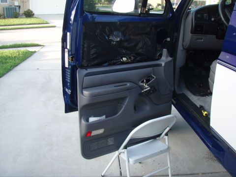 1996 Ford Bronco - The interior door panel of a 1996 Ford Bronco is removed, revealing insulation and wiring.