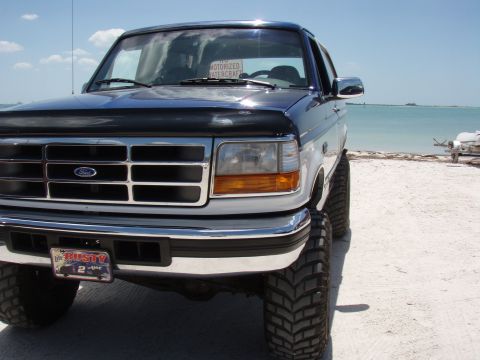 1996 Ford Bronco - This lifted 1996 Ford Bronco is parked on a sandy beach with the ocean in the background.