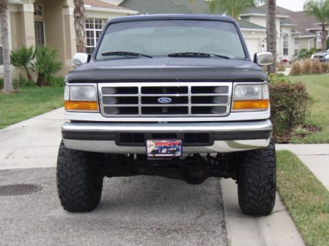 1996 Ford Bronco - Front view of a lifted 1996 Ford Bronco with custom license plate and large off-road tires.