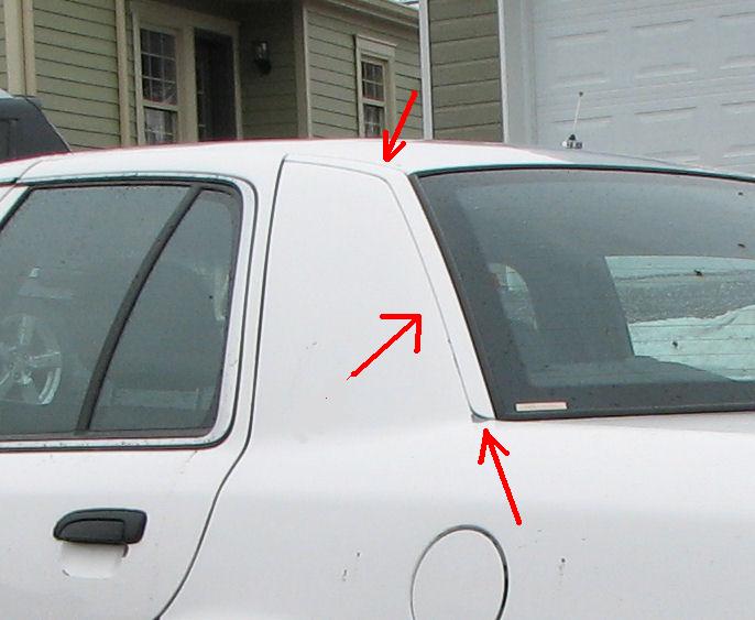 Rear quarter window and C-pillar of white sedan with red arrows pointing to trim