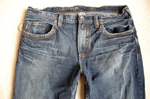 1968 Chrysler Town & Country - Close-up view of the front of a pair of blue jeans, showing pockets and waistband detail.