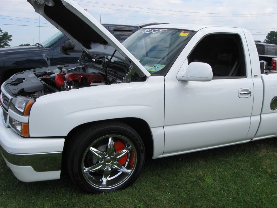 White pickup truck front view, hood open, chrome wheels, red brake calipers