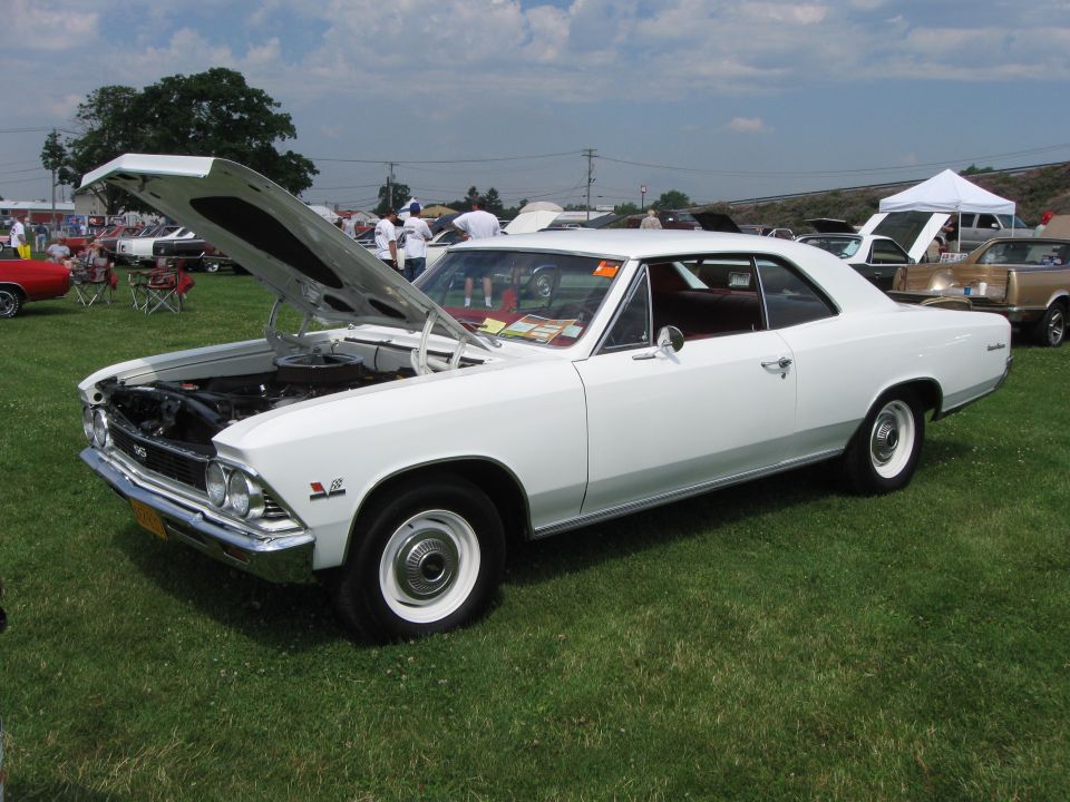 White 1966 coupe with hood open at a car show