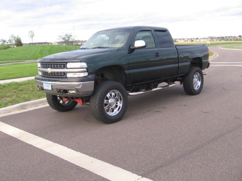2001 Chevrolet Silverado 1500 - A lifted 2001 Chevrolet Silverado 1500 pickup truck is shown from a three-quarter front angle on a paved surface.