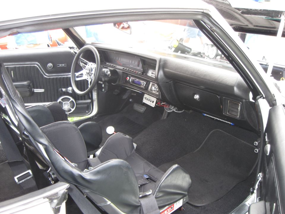 Black racing seats and dashboard of a classic car interior, viewed from the passenger side