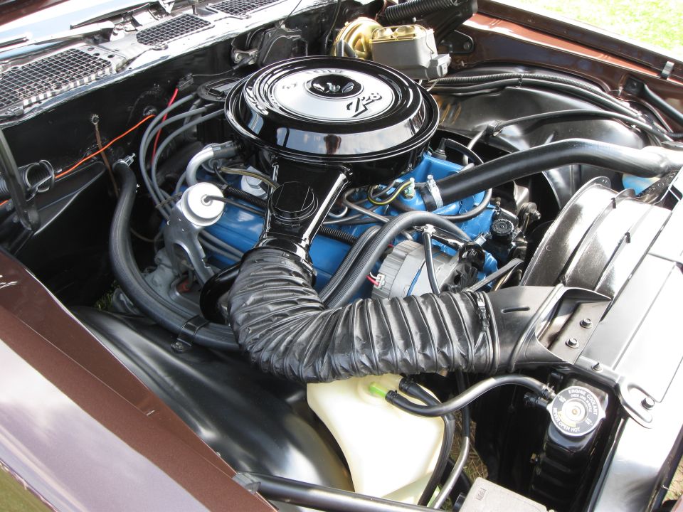 Engine bay with blue engine block, black air cleaner, and brown fender