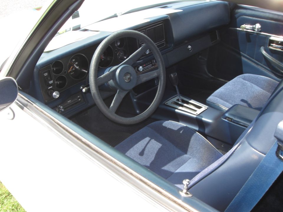 Blue fabric seats and dashboard of a car interior, showing the steering wheel and gear shifter