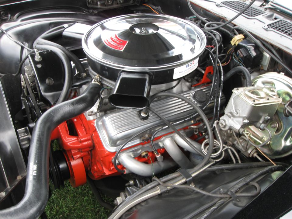 V8 engine block painted red, chrome air cleaner assembly, and exhaust headers