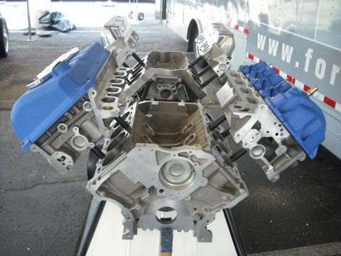 2007 Ford Mustang - Disassembled Ford V8 engine block and cylinder heads with blue valve covers.