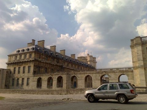 1991 Ford Crown Victoria - A silver Jeep Grand Cherokee is parked in front of a historic stone building under a cloudy sky.