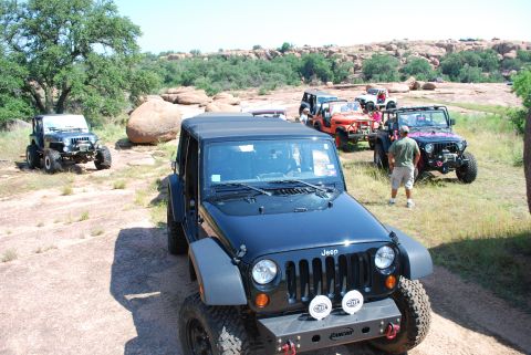 2008 Jeep Wrangler - A group of Jeep Wranglers are gathered on a rocky terrain, with one black Jeep prominently in the foreground.
