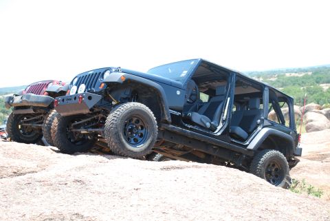 2008 Jeep Wrangler - Two Jeep Wranglers navigate a rocky trail, one with its doors removed, its interior and off-road capabilities.