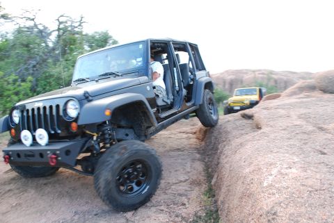 2008 Jeep Wrangler - Two Jeeps navigate a rocky, off-road trail under a bright sky.