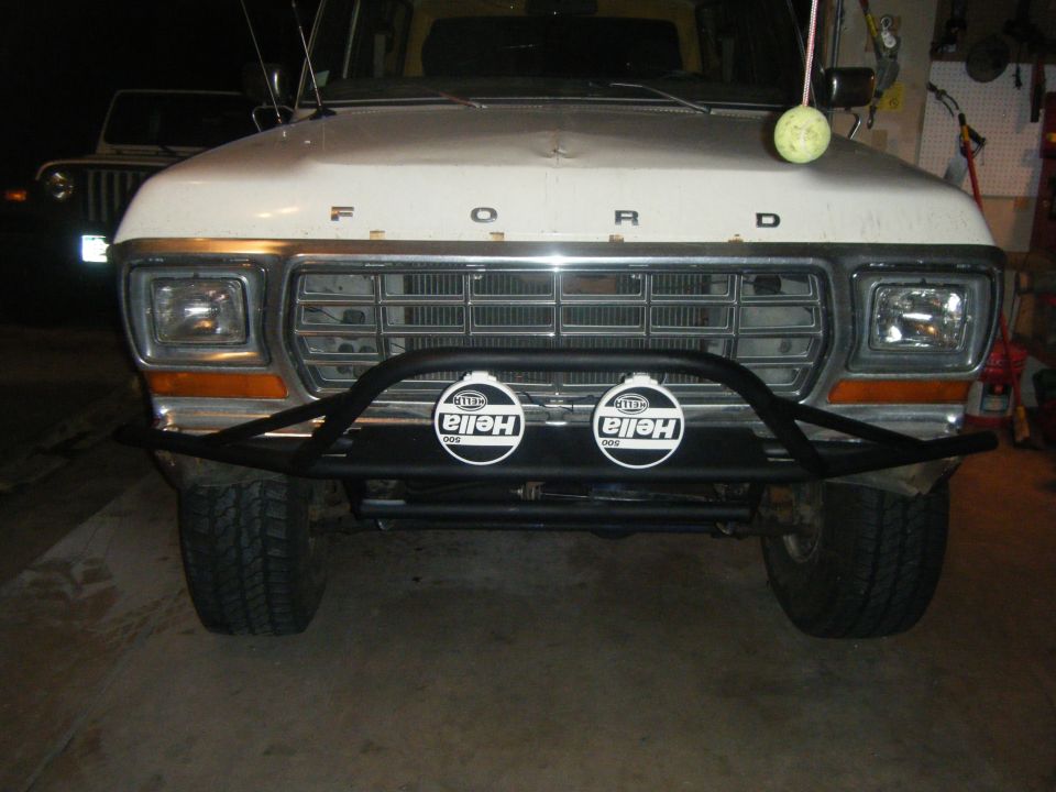 White 1978 Ford Bronco front end with a black bull bar and two Hella fog lights