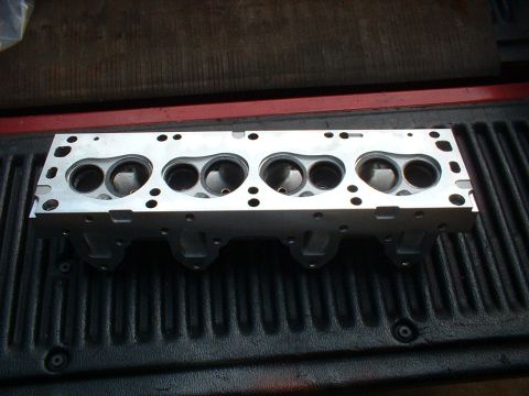 1968 Ford Galaxie - An aluminum engine cylinder head with six combustion chambers is shown from a top-down perspective.
