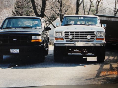 1995 Ford Bronco - A white Ford truck with a "USA" sticker on the windshield is parked next to a black Ford truck.