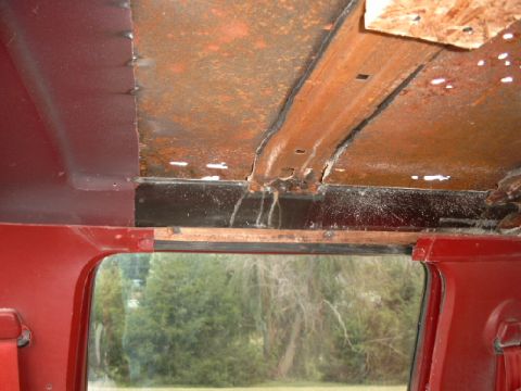 1990 Ford Bronco - Interior view showing significant rust and water damage on the ceiling and window frame.