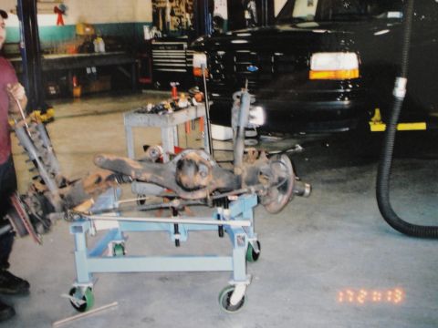1995 Ford Bronco - Rear axle assembly removed from a vehicle and placed on a rolling cart for service.