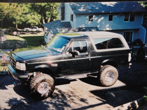 1995 Ford Bronco - This 1995 Ford Bronco is shown in a three-quarter front view, parked outside a residential home.