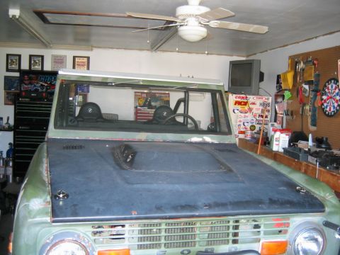 1992 Ford Mustang - This vintage Ford Bronco is parked inside a garage, showing its distinctive grille and hood.