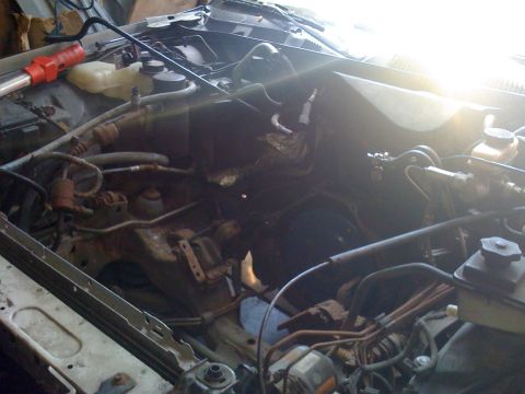 1996 Ford Crown Victoria - The engine bay of a vehicle is shown with the engine partially disassembled.