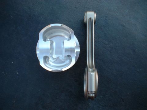 1968 Ford Galaxie - A close-up view of an engine piston and connecting rod assembly against a dark background.