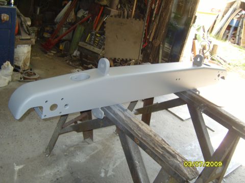 1989 Ford Bronco - Bumper assembly primed and ready for paint, resting on sawhorses in a garage.