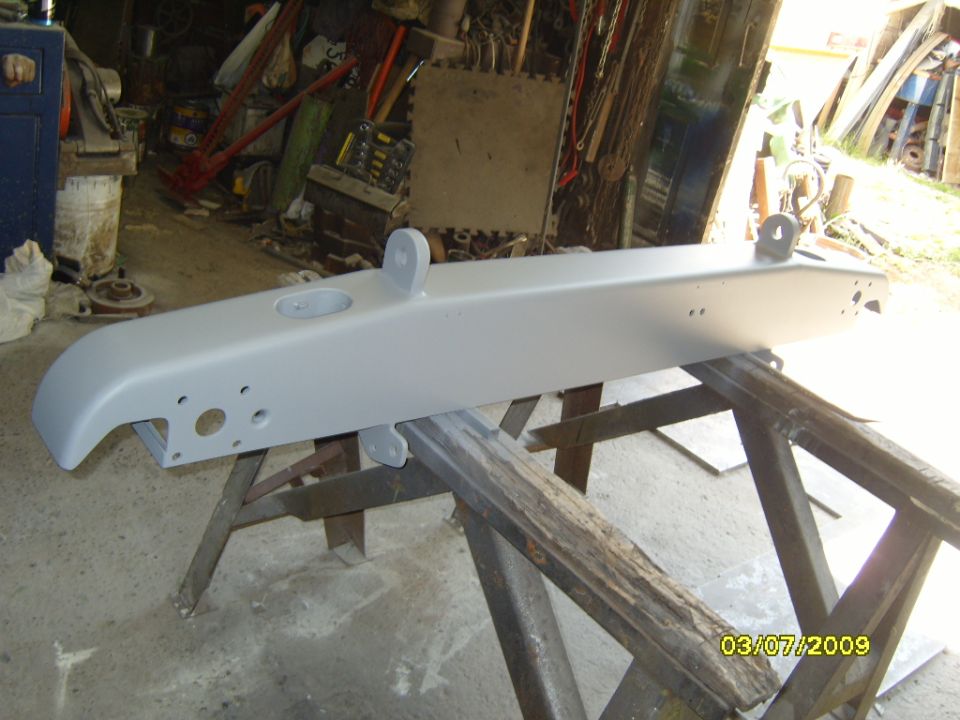 Primed bumper assembly on sawhorses in a workshop. Date stamp reads 03/07/2009