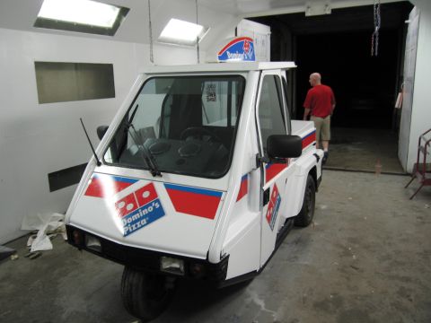 2001 Ford Crown Victoria - White three-wheeled Domino's Pizza delivery vehicle with branding on the front and side.
