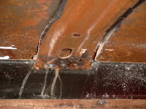 1990 Ford Bronco - This image shows a close-up of heavily rusted metal, likely from a vehicle's undercarriage or body panel.