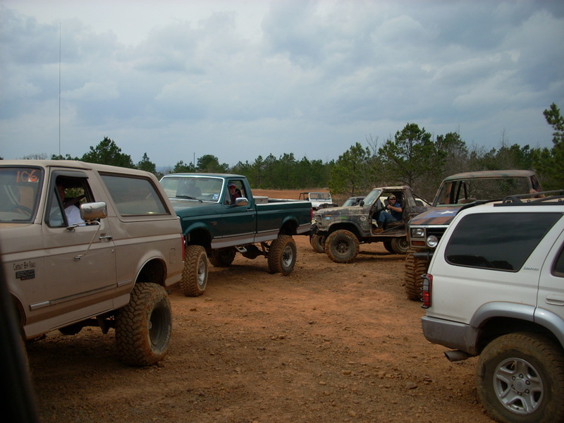 Tan 1992 Ford Bronco with lifted suspension and off-road tires, parked on dirt
