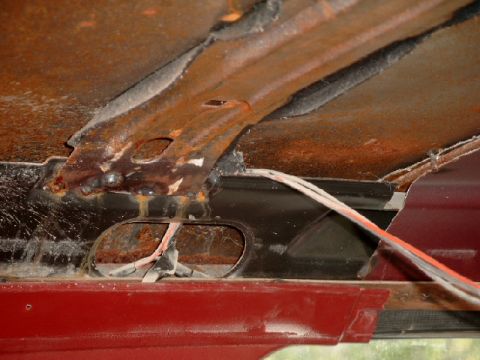 1990 Ford Bronco - Close-up of a heavily rusted interior panel with exposed wiring.