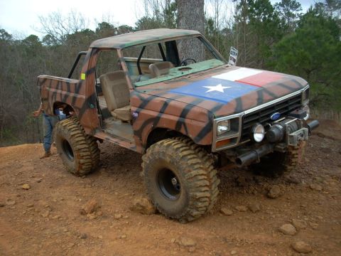 1996 Ford Bronco - This modified SUV features a Texas flag on its hood and aggressive off-road tires.