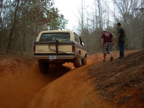 1996 Ford Bronco - A tan Ford Bronco navigates a steep dirt path with two onlookers.
