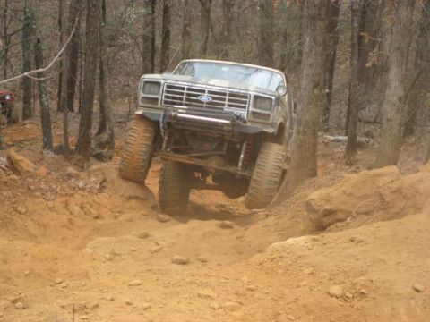 1996 Ford Bronco - This modified Ford Bronco navigates a challenging off-road course with its front wheels lifted high.