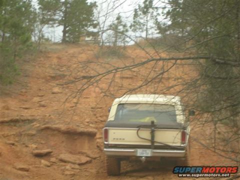 1996 Ford Bronco - A 1978 Ford Bronco navigates a steep, rutted dirt path surrounded by trees.