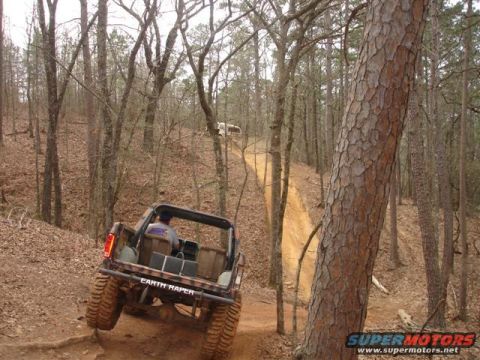 1996 Ford Bronco - An off-road vehicle navigates a steep, wooded trail during an event in 2009.