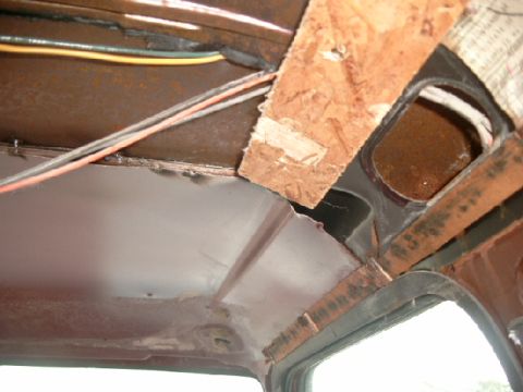 1990 Ford Bronco - View of the interior ceiling showing exposed wiring and makeshift wood paneling, with a Supermotors.net logo in the corner.