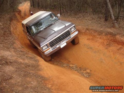 1996 Ford Bronco - A classic Ford Bronco navigates a steep, muddy off-road trail.