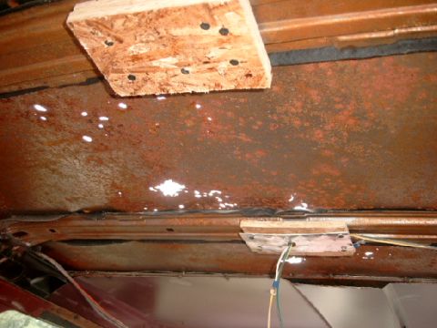 1990 Ford Bronco - Vehicle interior roof shows significant rust and water damage, with makeshift wood bracing.