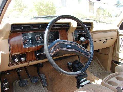 1984 Ford F-250 - Interior view of a 1984 Ford F-250, wood grain trim and XLT badging.