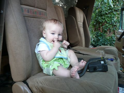 1990 Ford Bronco - Baby sits in the interior of a vehicle, next to a radio.