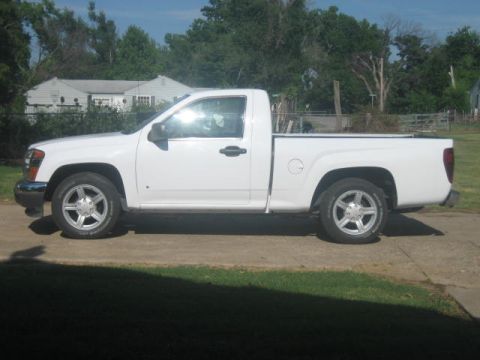 1996 Ford Thunderbird - A white pickup truck is parked on a concrete driveway with a grassy area in the foreground and houses in the background.