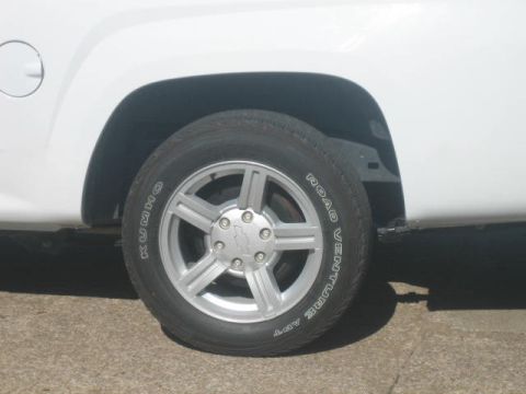 1996 Ford Thunderbird - Close-up of a white vehicle's wheel and fender, showing tire details and a silver alloy rim.