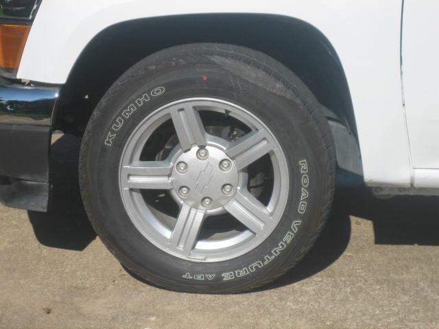 White vehicle's front wheel and Kumho Road Venture APT tire