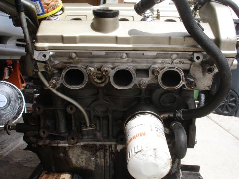1990 Ford Taurus - Engine block with oil filter and hoses. The album claims it is a 1990 Ford Taurus.