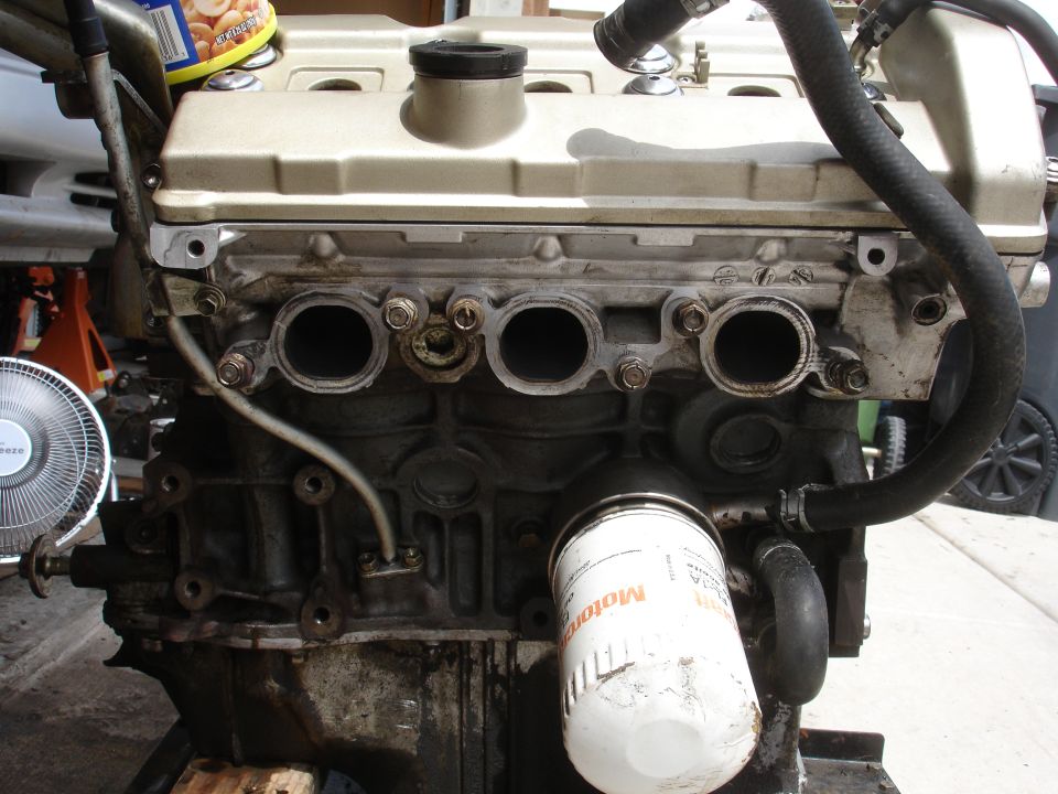 Engine block with oil filter attached. A can of nuts is on top